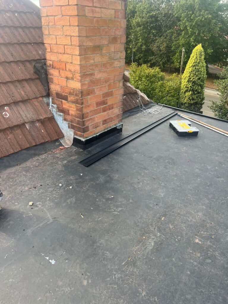 This is a photo of a flat roof which has just been repaired, there is also a chimney stack and some leadwork has also been dressed. Works carried out by LS Roofing Chalfont St Giles